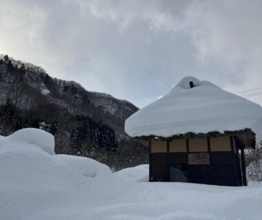 Thatched cottage covered in deep snow outside Kinasa no Yu, Nagano mountain setting