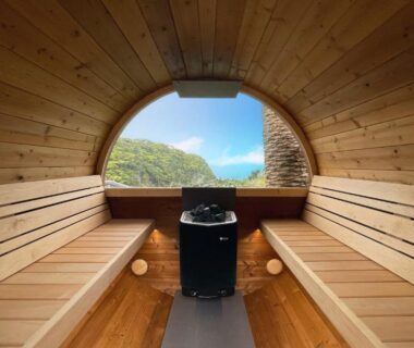 Barrel-shaped wooden sauna interior with central heater and round window, 鵜原館 Ubarakan, Chiba Kantō