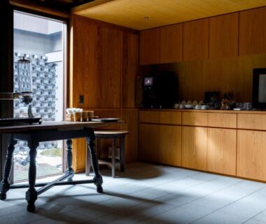 Sunlit wooden lounge with table and cabinetry at 黒梅屋 Kurumiya in Ishikawa, Chūbu Japan